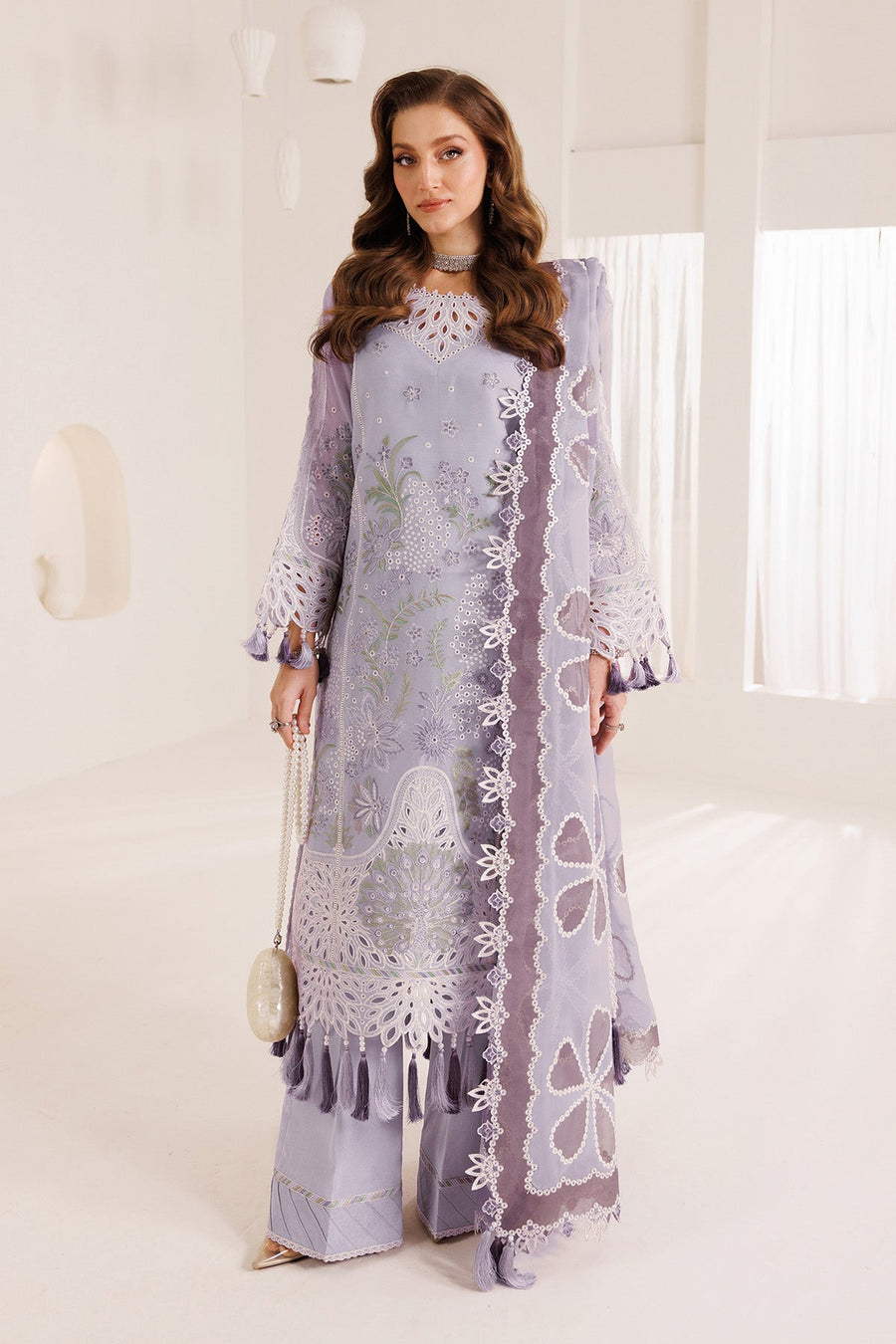 Woman wearing a light purple chiffon embroidered formal suit holding a heart-shaped bag