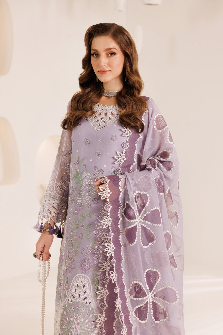 Woman with long wavy hair wearing a detailed chiffon suit with embroidered dupatta
