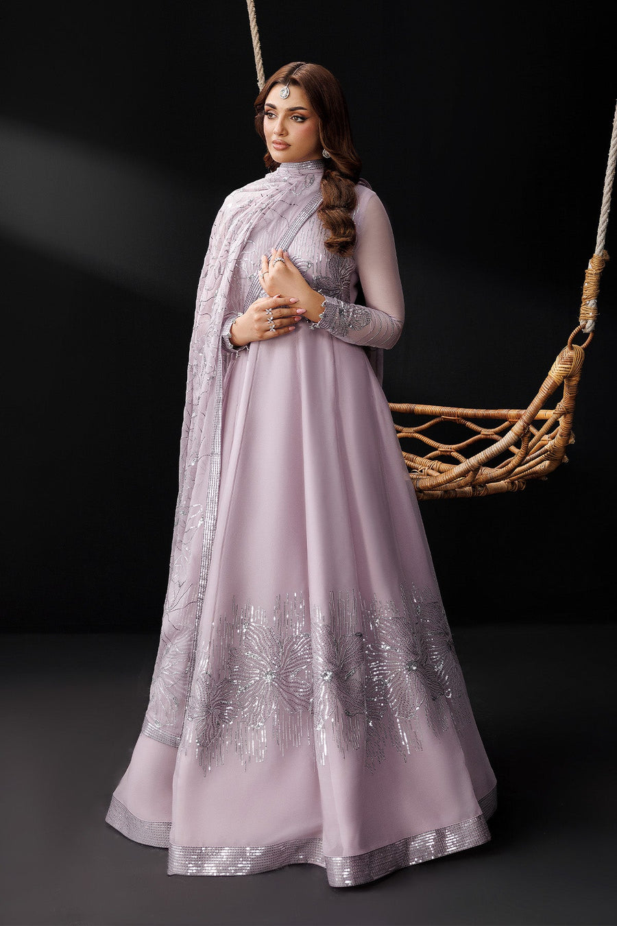 Woman wearing elegant lavender maxi dress standing by swing