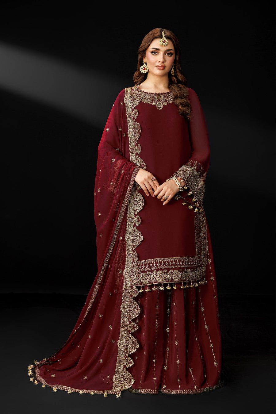 Full front view of woman in maroon chiffon suit with embroidered borders and tassels
