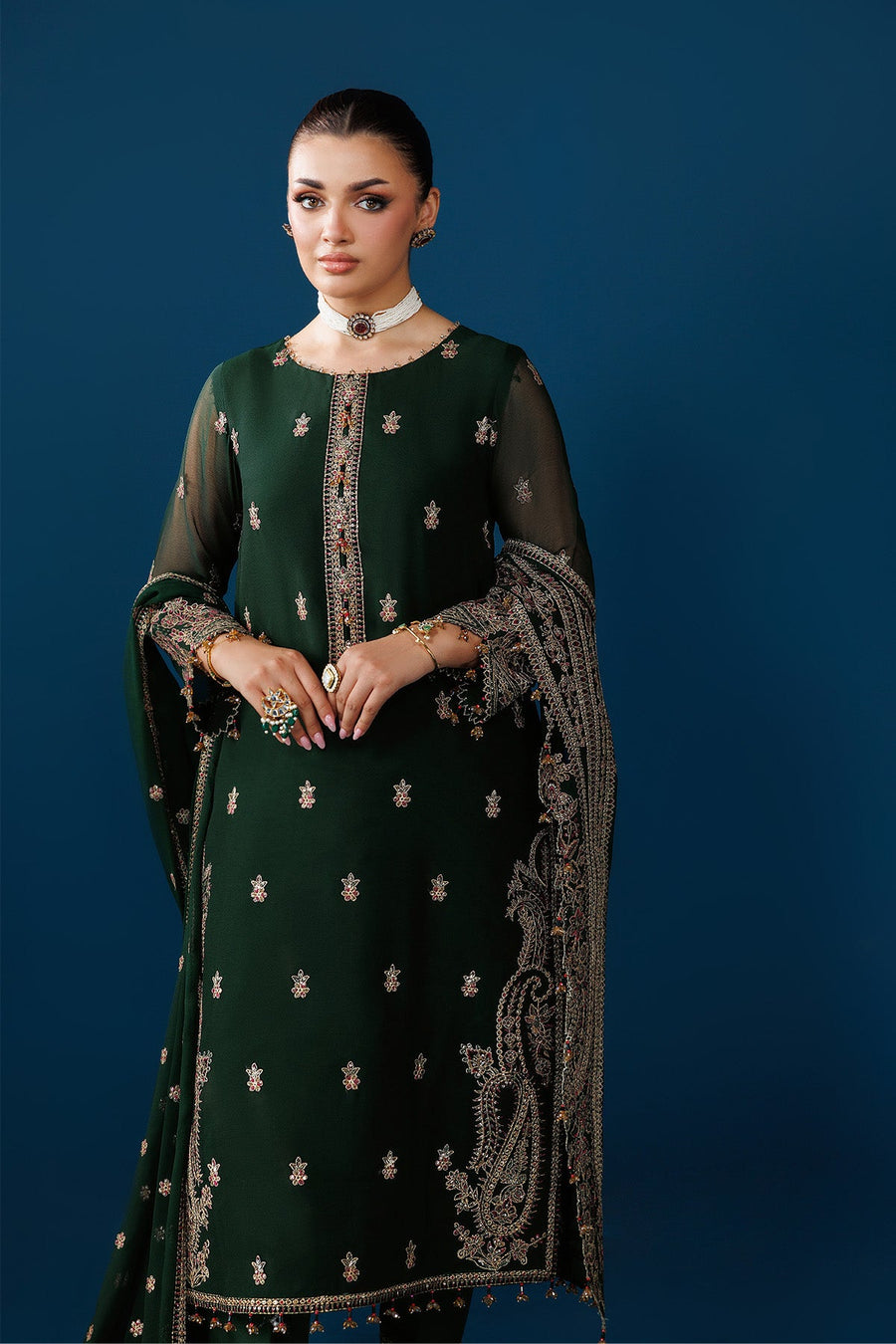 Side angle highlighting detailed embroidery on sleeves and trouser cuffs