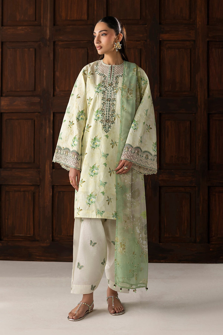 Woman wearing embroidered lawn three-piece suit with pastel green floral prints, front view