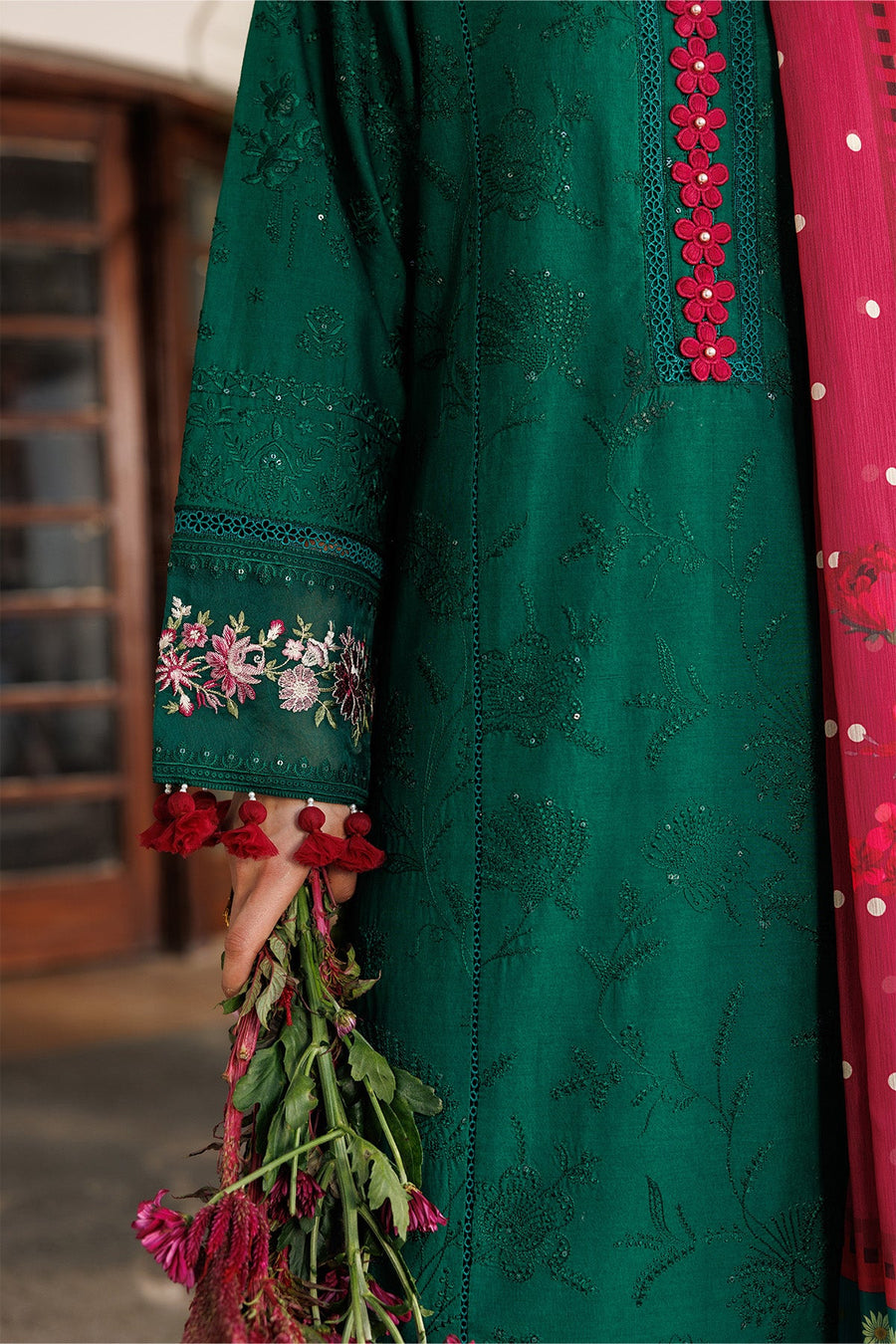 Close-up of woman dressed in embroidered green lawn suit with floral printed red chiffon dupatta