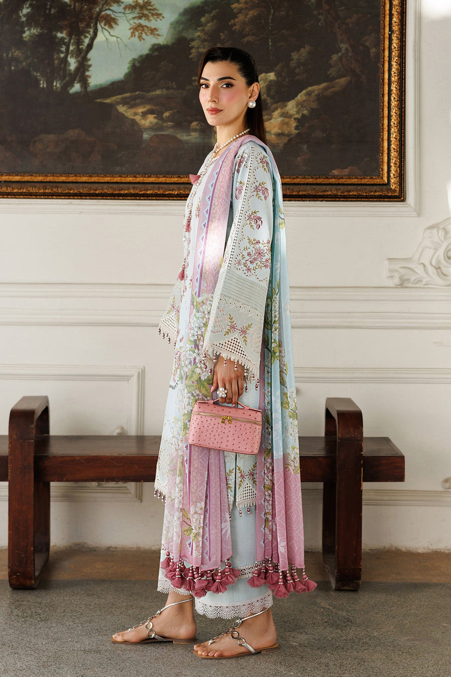 Side view of the embroidered lawn suit showcasing detailed sleeve embroidery and woman holding pink handbag