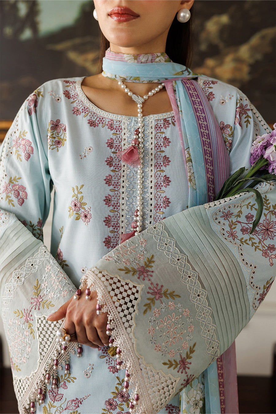 Full frontal view of woman presenting the embroidered lawn suit with pastel colors