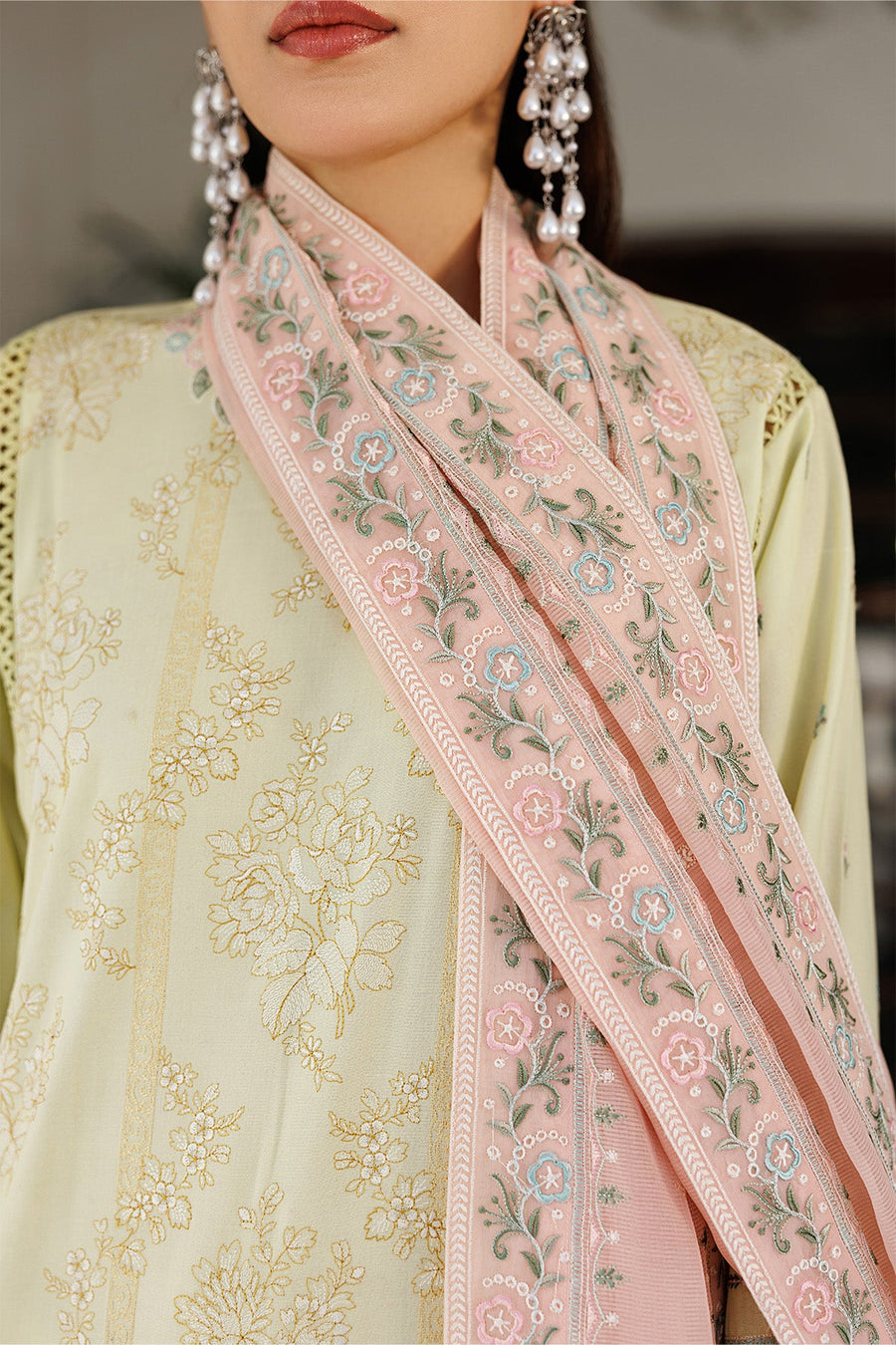 Close-up of mint green handbag held by woman wearing embroidered lawn shirt
