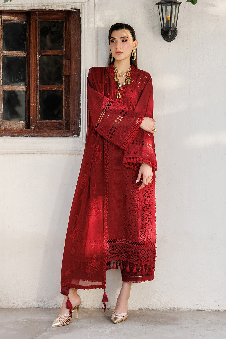 Close-up of embroidered sleeves and floral pattern on red lawn fabric with lacework