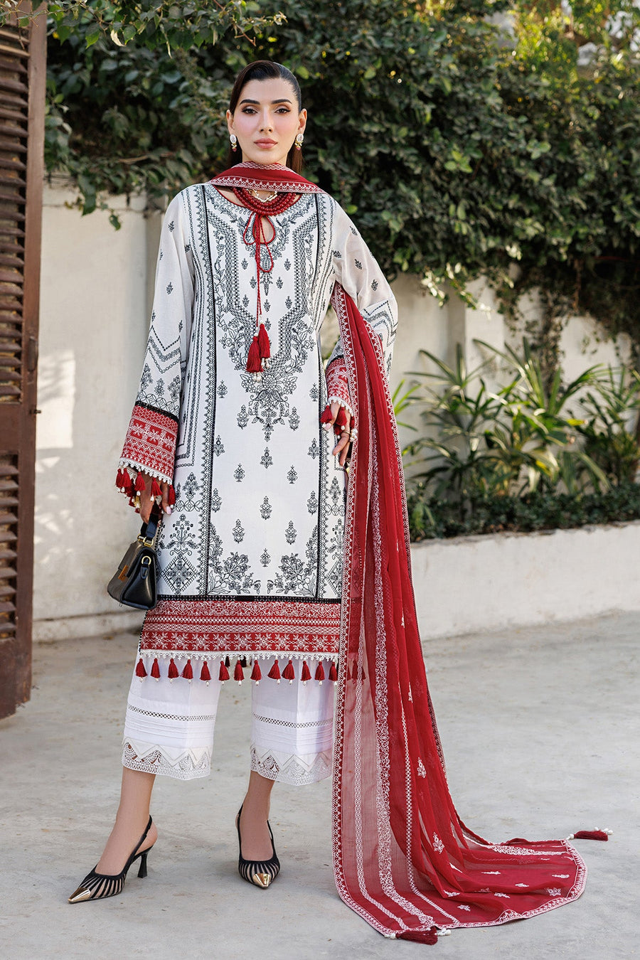 Front view of woman in elegant embroidered lawn suit with red dupatta draped over shoulder