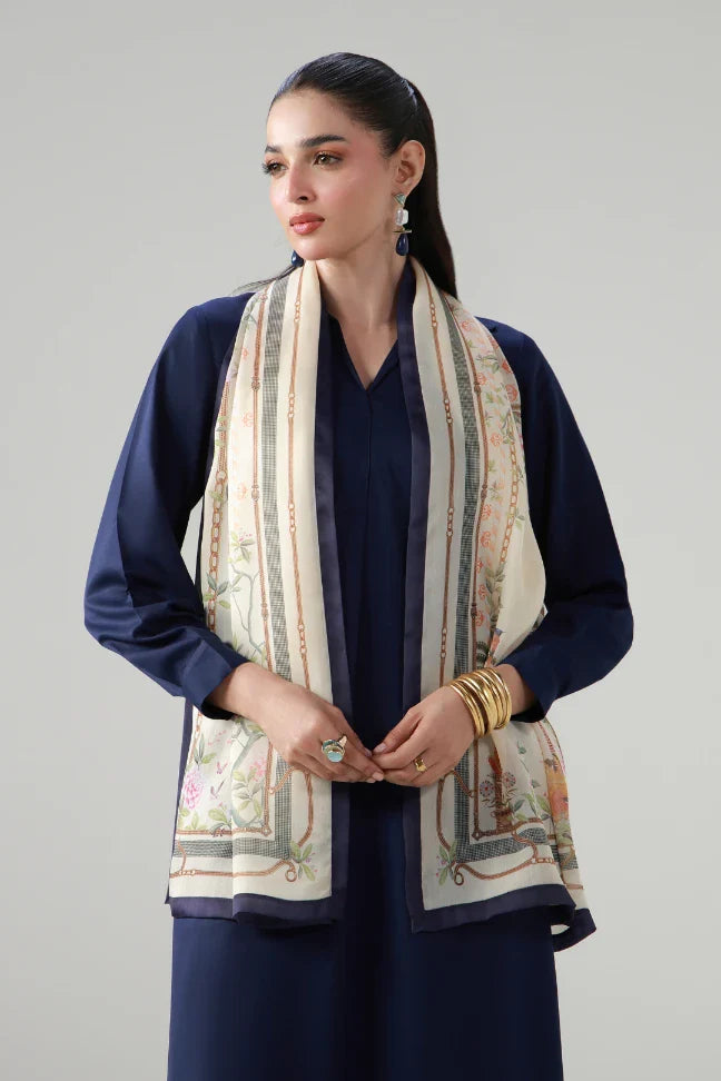 Woman wearing elegant cream-colored scarf with floral and chain motifs over a navy outfit