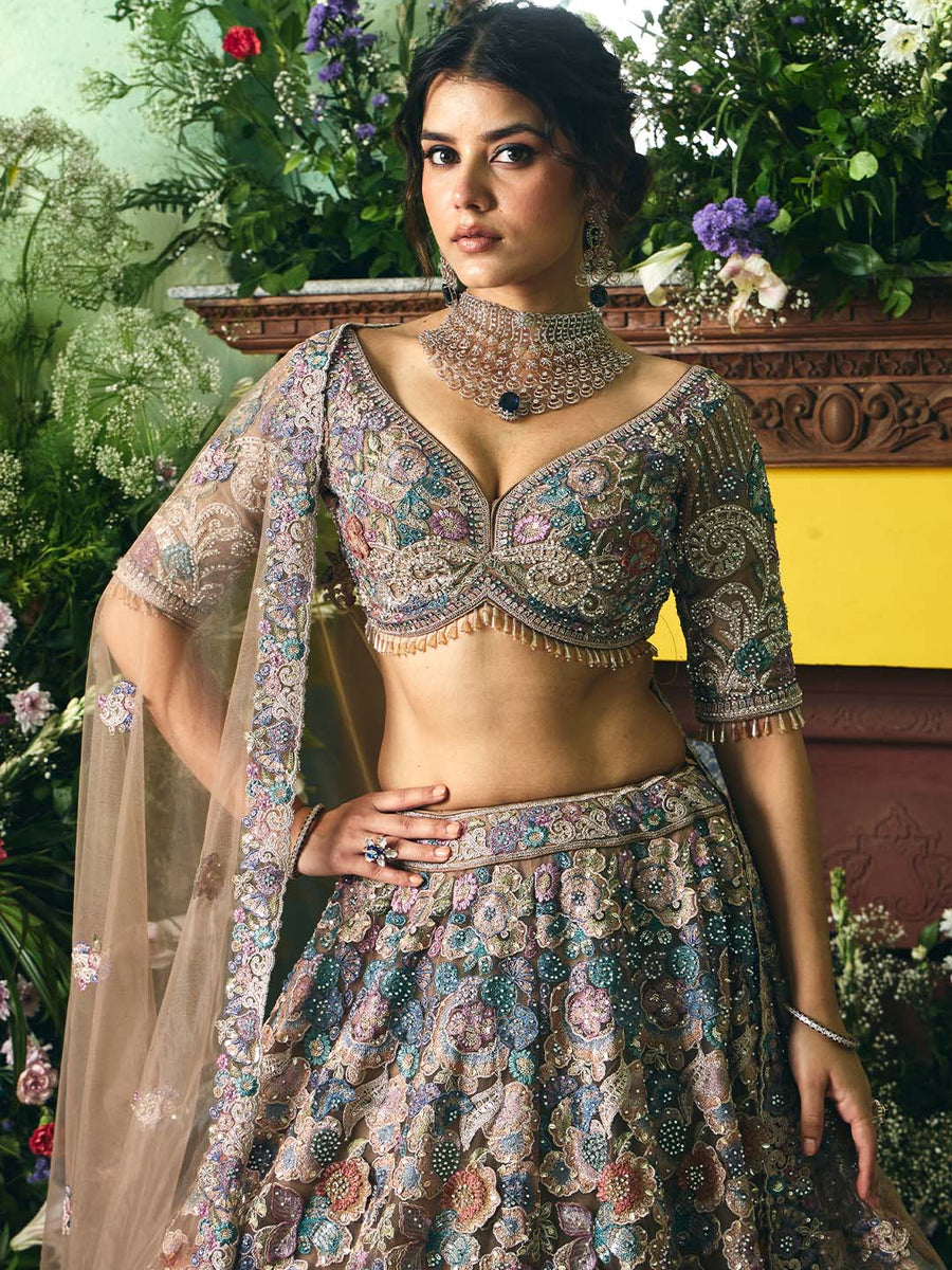 Close-up of the detailed multicolored floral embroidery on a deep V-neck choli with quarter-length sleeves paired with a coordinated lehenga skirt.