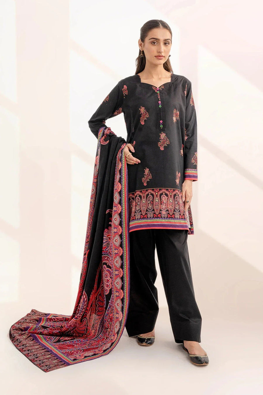 Woman wearing black three-piece lawn suit with print details and holding printed dupatta