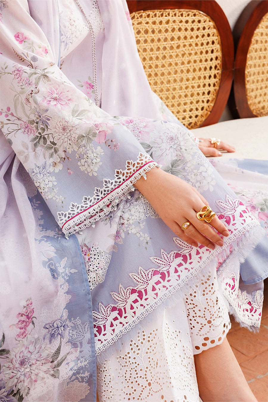 Close-up of embroidered sleeve border and intricate white eyelet lace pants highlighting craftsmanship.