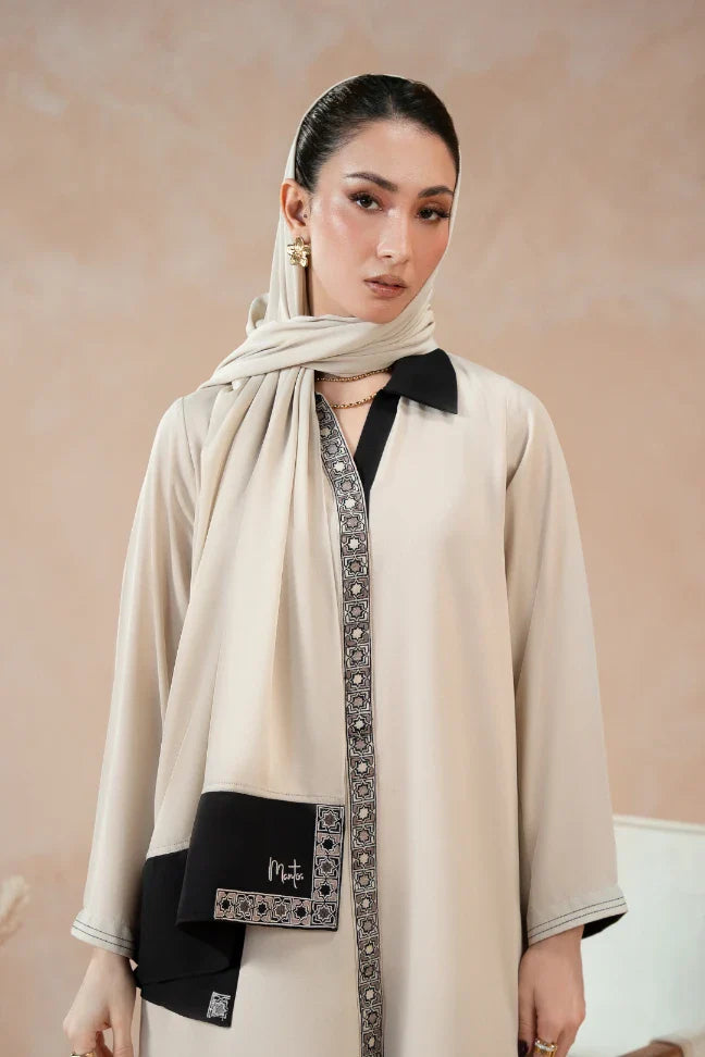 Woman wearing a beige and black embroidered stitched suit with matching embroidered scarf, styled in a formal and elegant manner.