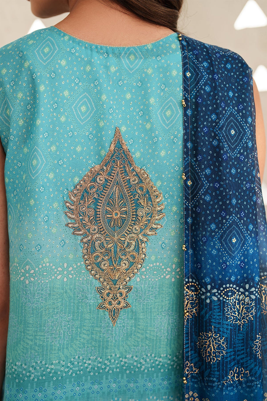 Sleeveless version of the teal to navy ombre embroidered lawn suit styled with gold clutch and stacked gold bangles, with matching printed blue dupatta