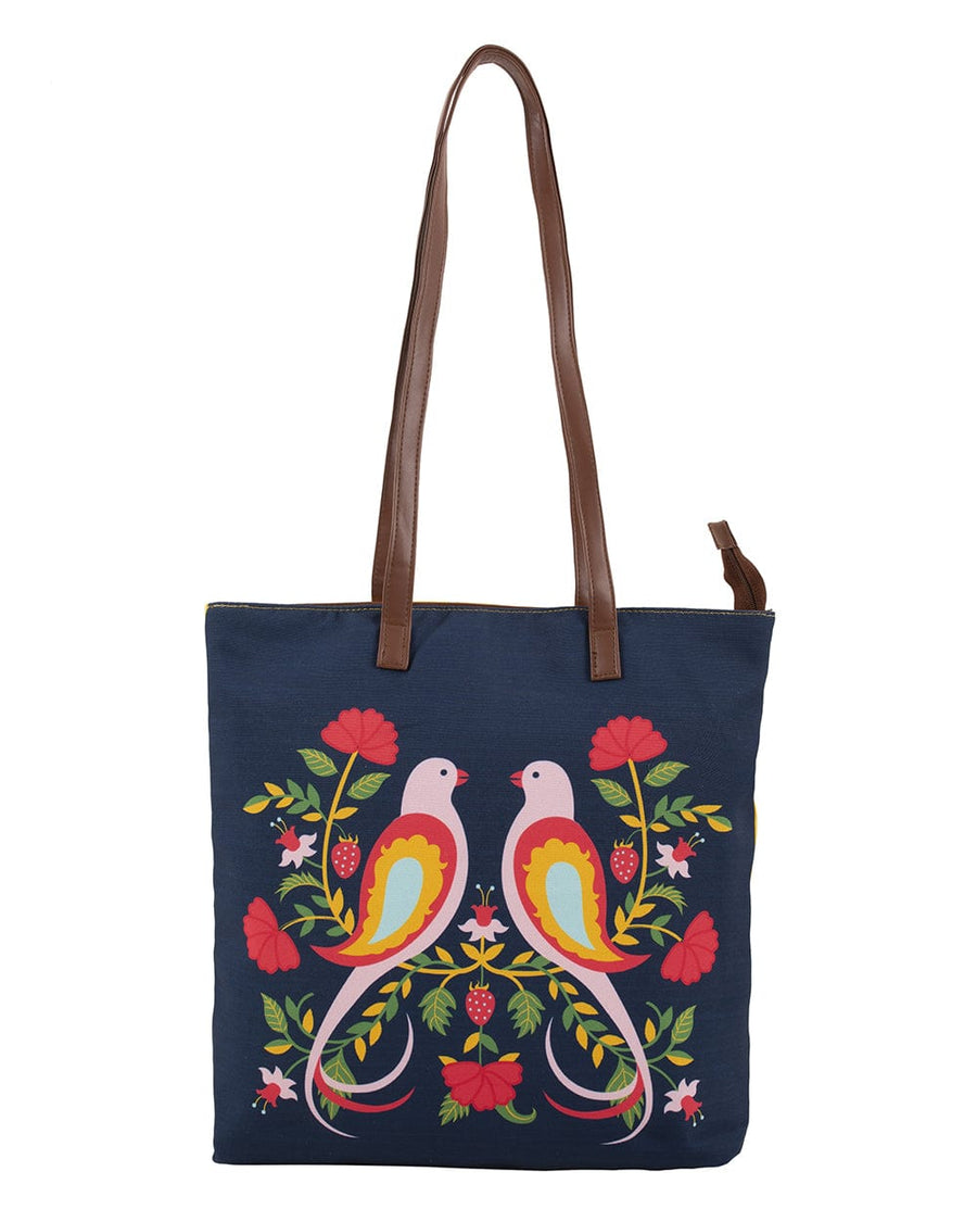 Feathered Mates tote bag in navy blue with colorful bird and floral print on front and brown leather-like shoulder straps