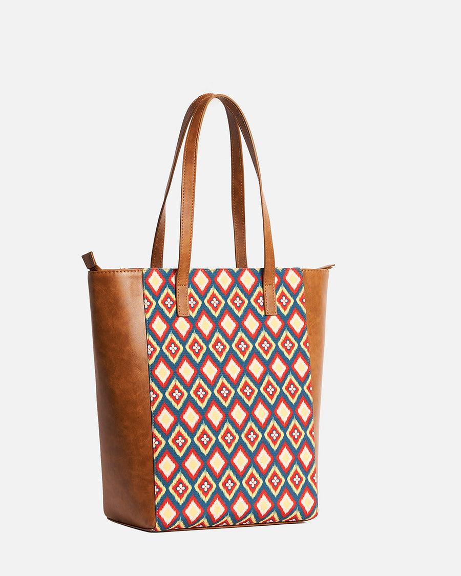 Side profile of Teal by Chumbak tote bag showing leather panel and patterned fabric center panel with sturdy handles