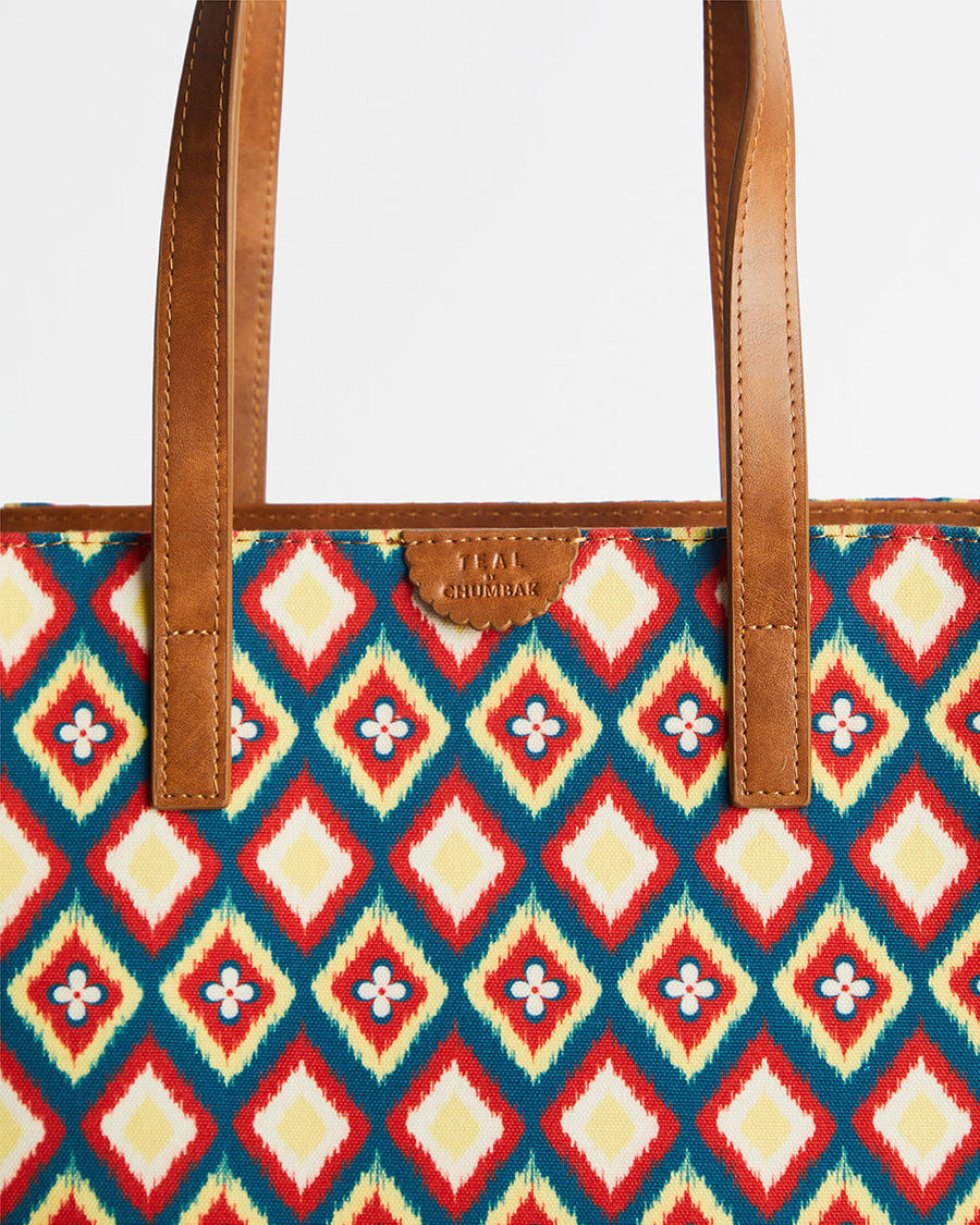 Close-up of tote bag showing intricate diamond embroidery on fabric panel with leather-like handles and Teal by Chumbak branding