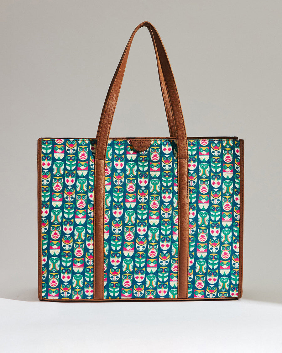 Canvas tote bag with teal and pink owl and leaf pattern, featuring brown leather straps and trim