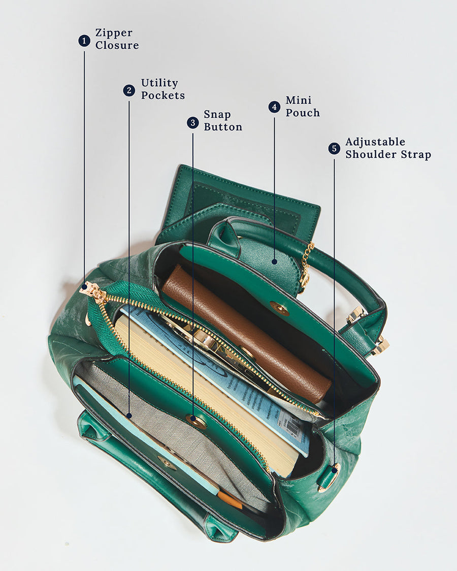 Top view of emerald handbag interior showing zipper closure, utility pockets, mini pouch, and adjustable shoulder strap
