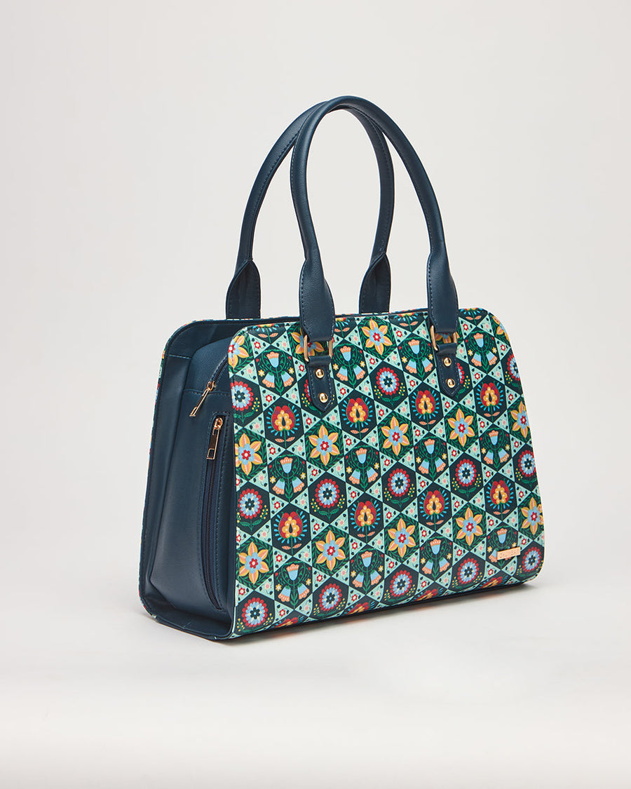 Front angled view of floral patterned tote bag with navy blue vegan leather sides and handles on white background
