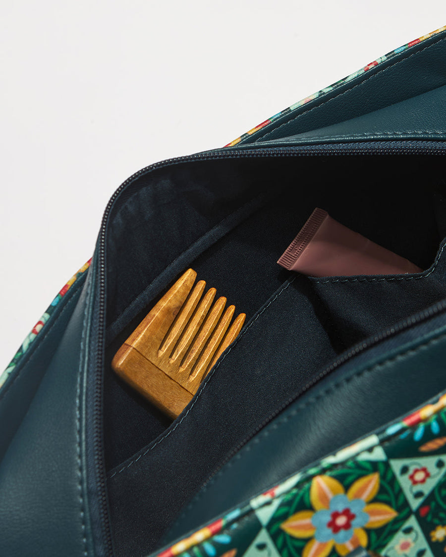 Detailed close-up of floral pattern exterior and sturdy navy handles with gold rivets