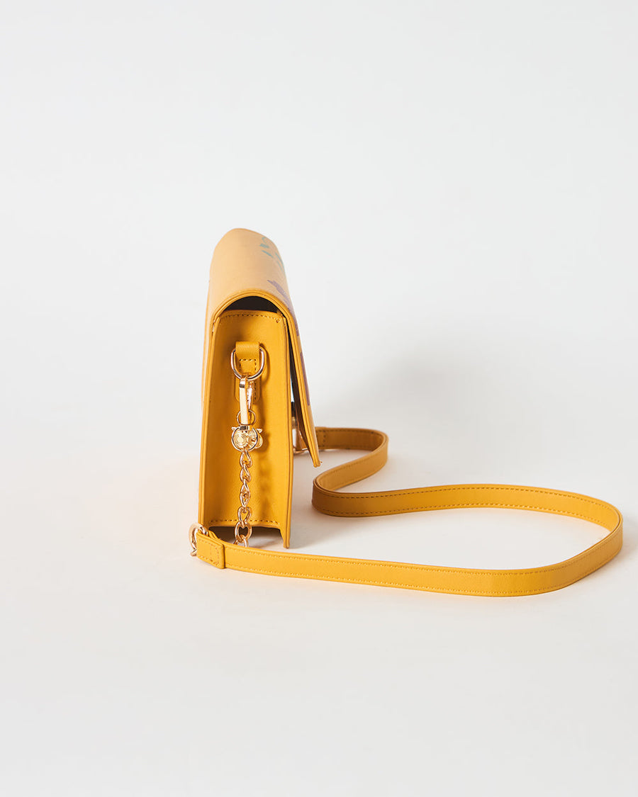Front view of mustard yellow floral shoulder bag with gold-tone clasp and floral print on white background