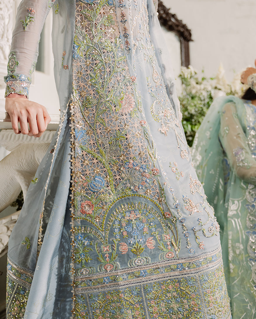 Detailed close-up of intricate floral embroidery featuring multi-colored threadwork and sequins on the dress's lower front panel