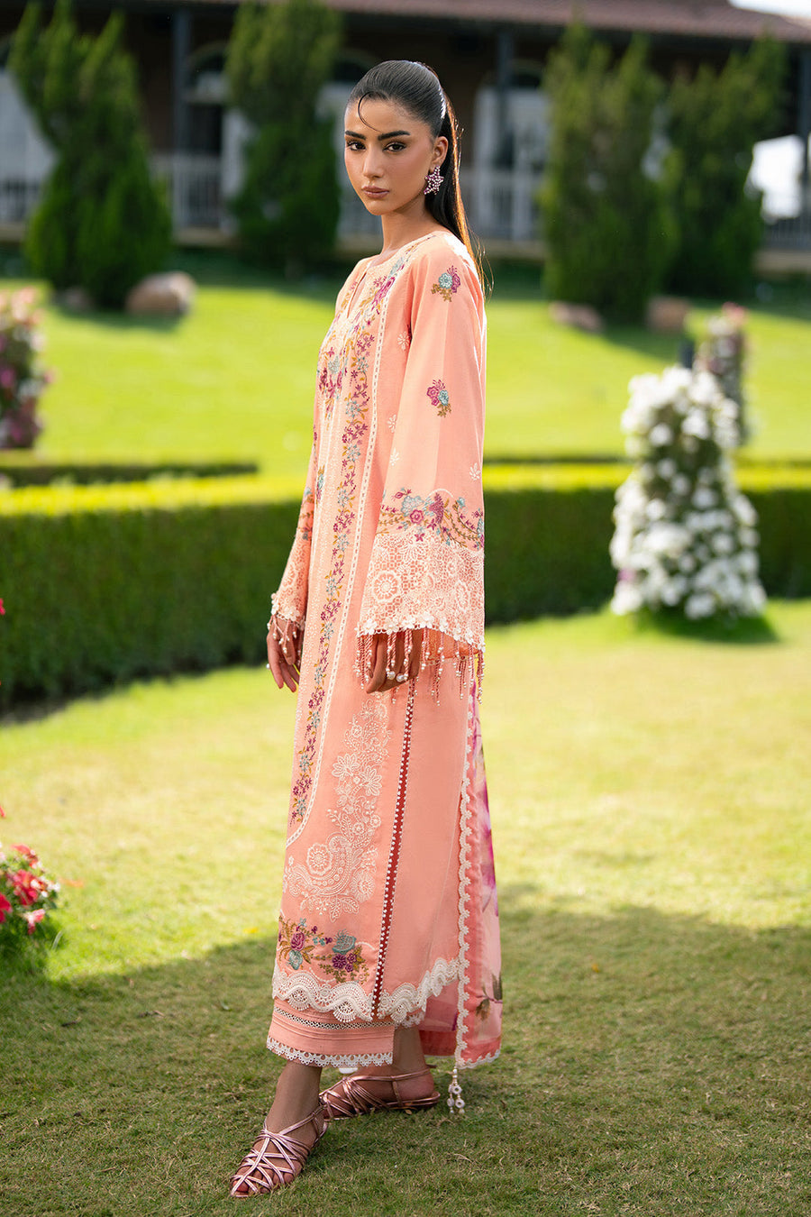 Side view of peach embroidered lawn suit showing detailed lace and bead fringed sleeves