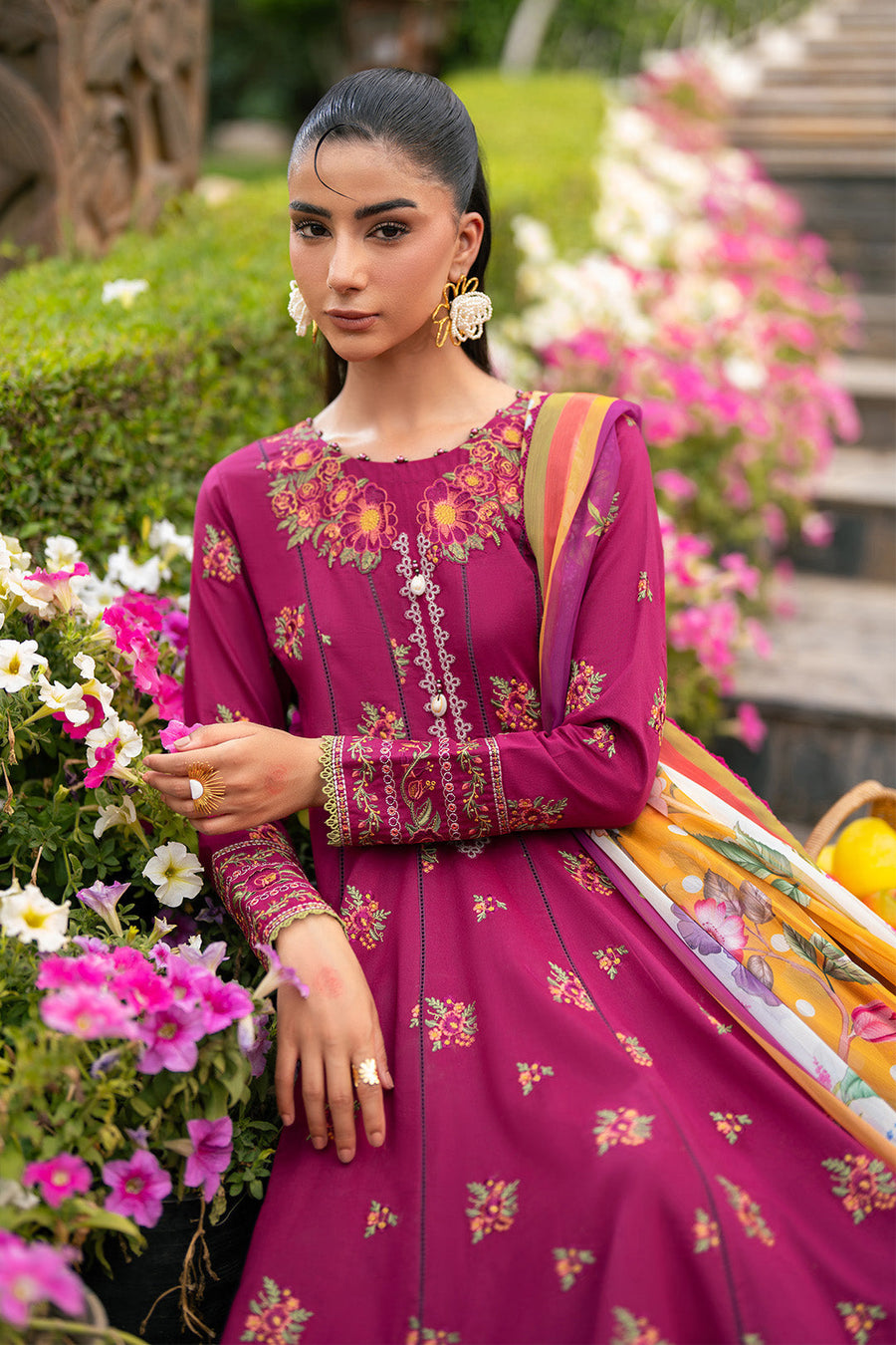 Woman posing with magenta embroidered floral maxi dress and pleated skirt outdoors