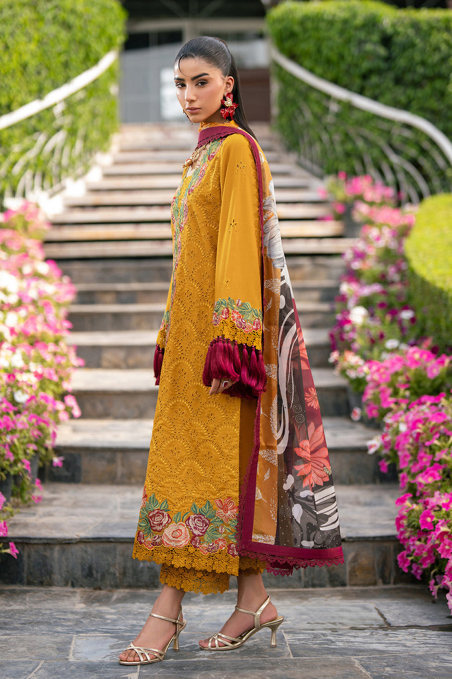 Close-up shot of sleeve embroidery and maroon tassel detailing on mustard yellow fabric