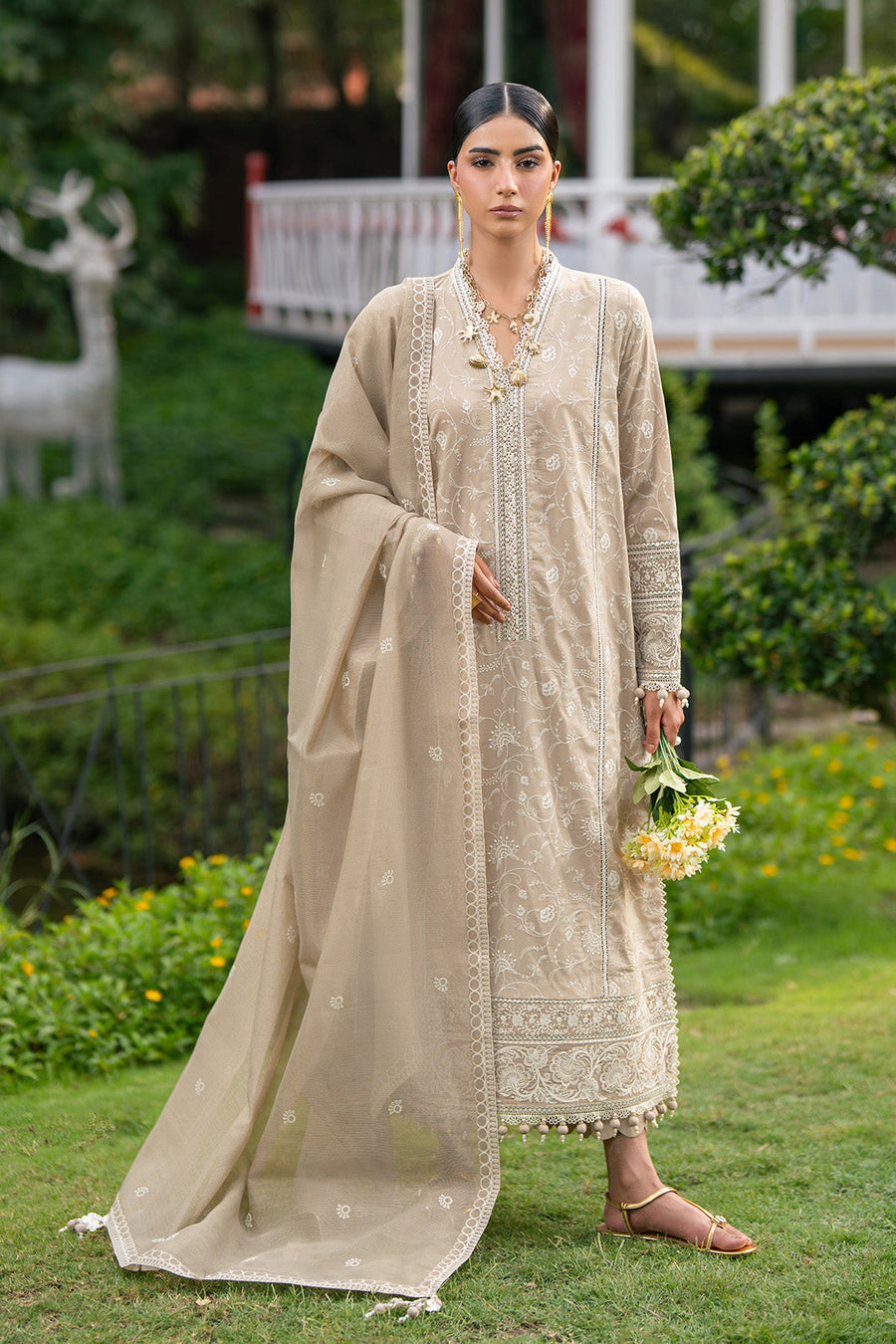 Model holding embroidered Munar dupatta with embroidered borders and pom-poms