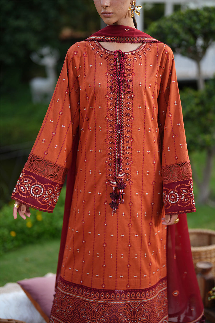 Close up of maroon dupatta with embroidered motifs and tassels