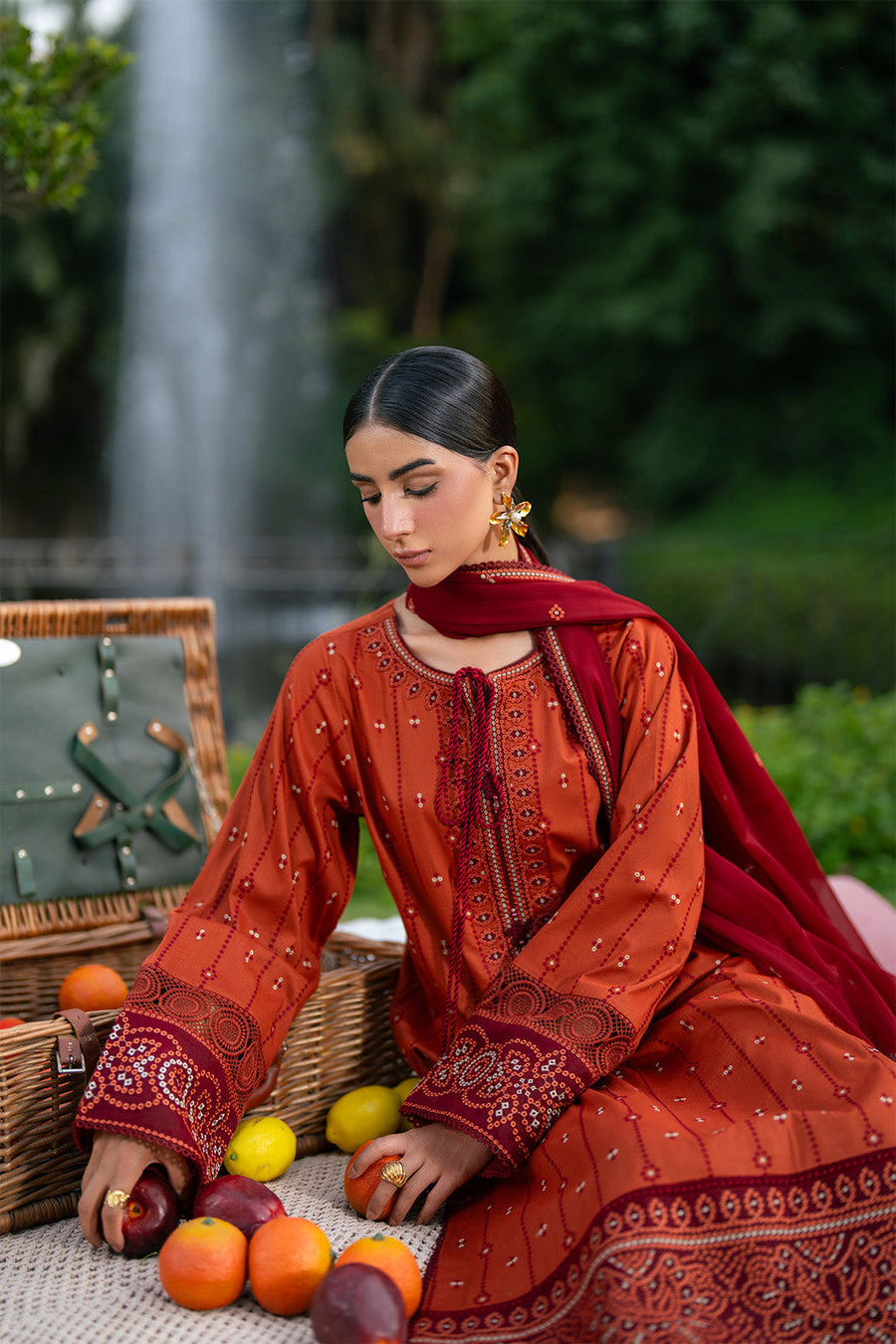 Side view of rust orange embroidered lawn suit with maroon detailed borders