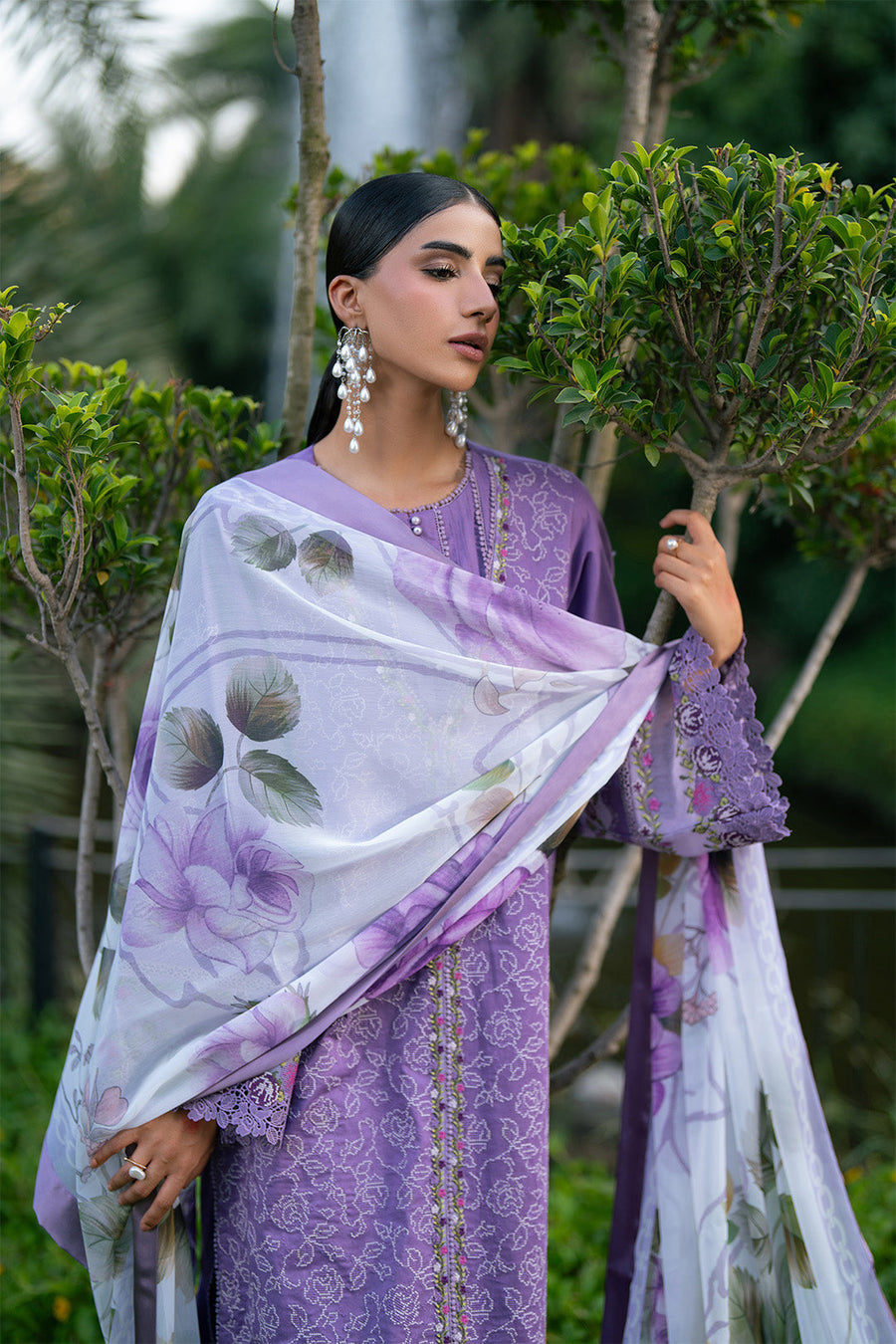 Model draping floral chiffon dupatta with purple lawn suit and statement earrings