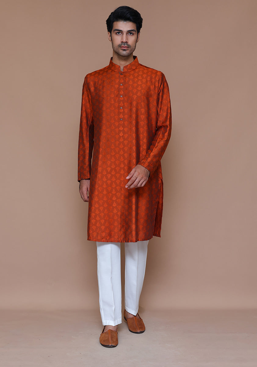 Side angled view of embroidered rust kurta showing fabric and button details on male model