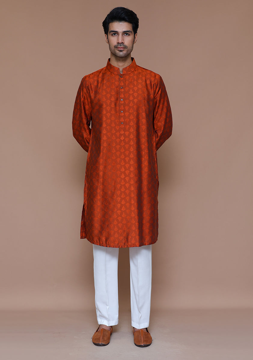 Front view of rust embroidered jamawar kurta on male model with white pants and slip-on brown shoes