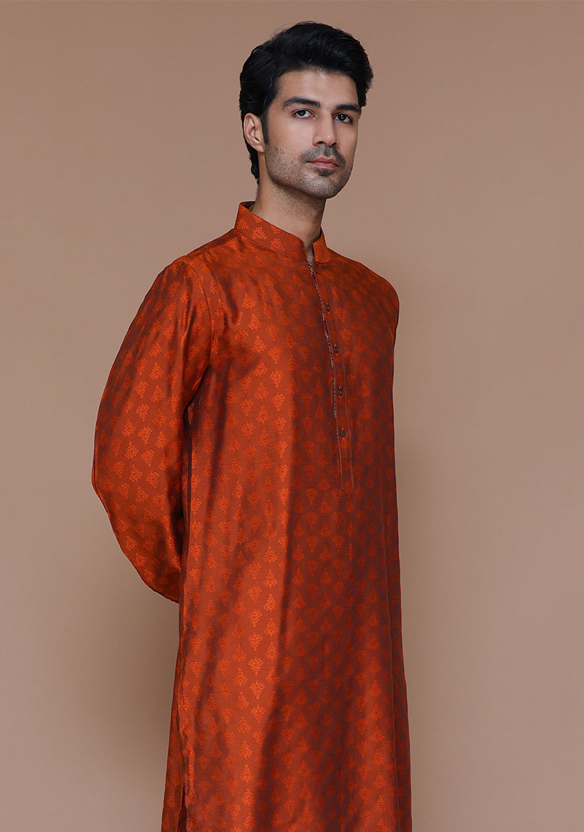 Close-up portrait showing detailed embroidery and band collar of rust-colored jamawar kurta on male model