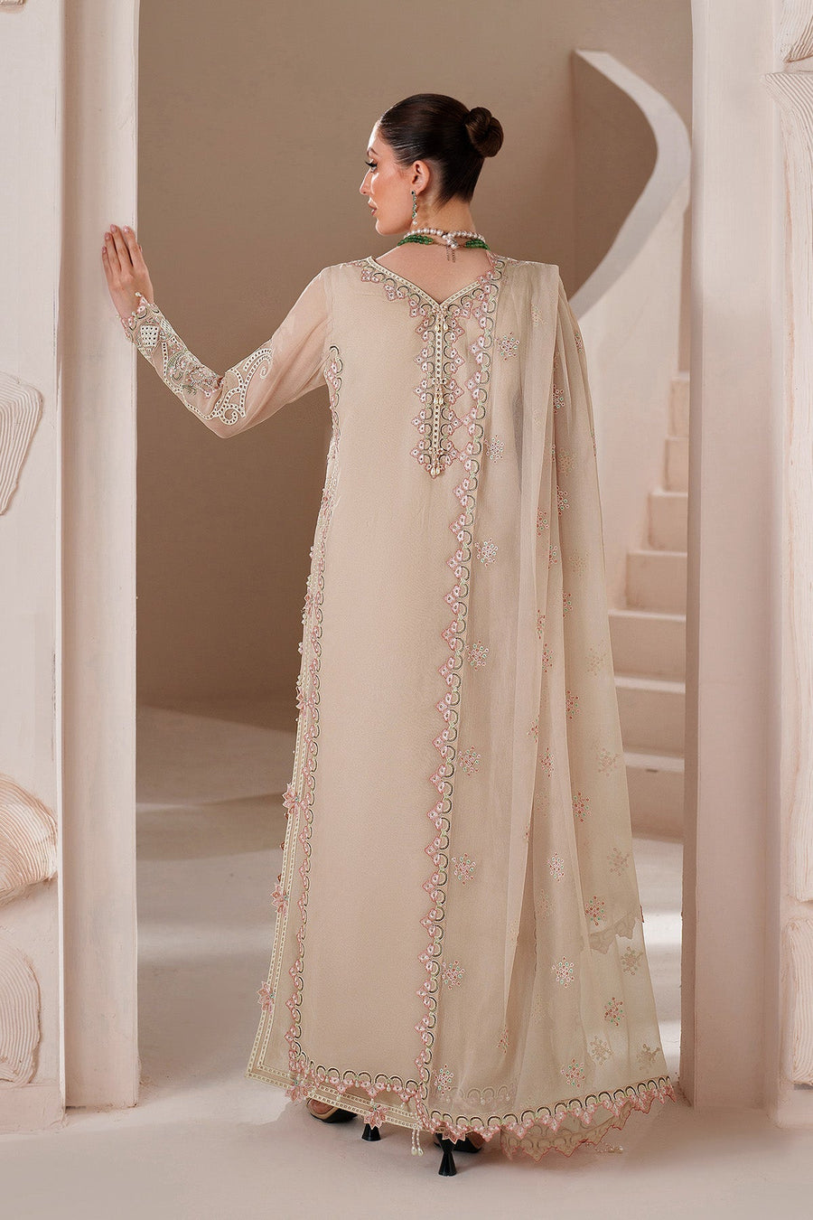 Back view revealing embroidered deep neckline and flowing dupatta on chiffon dress