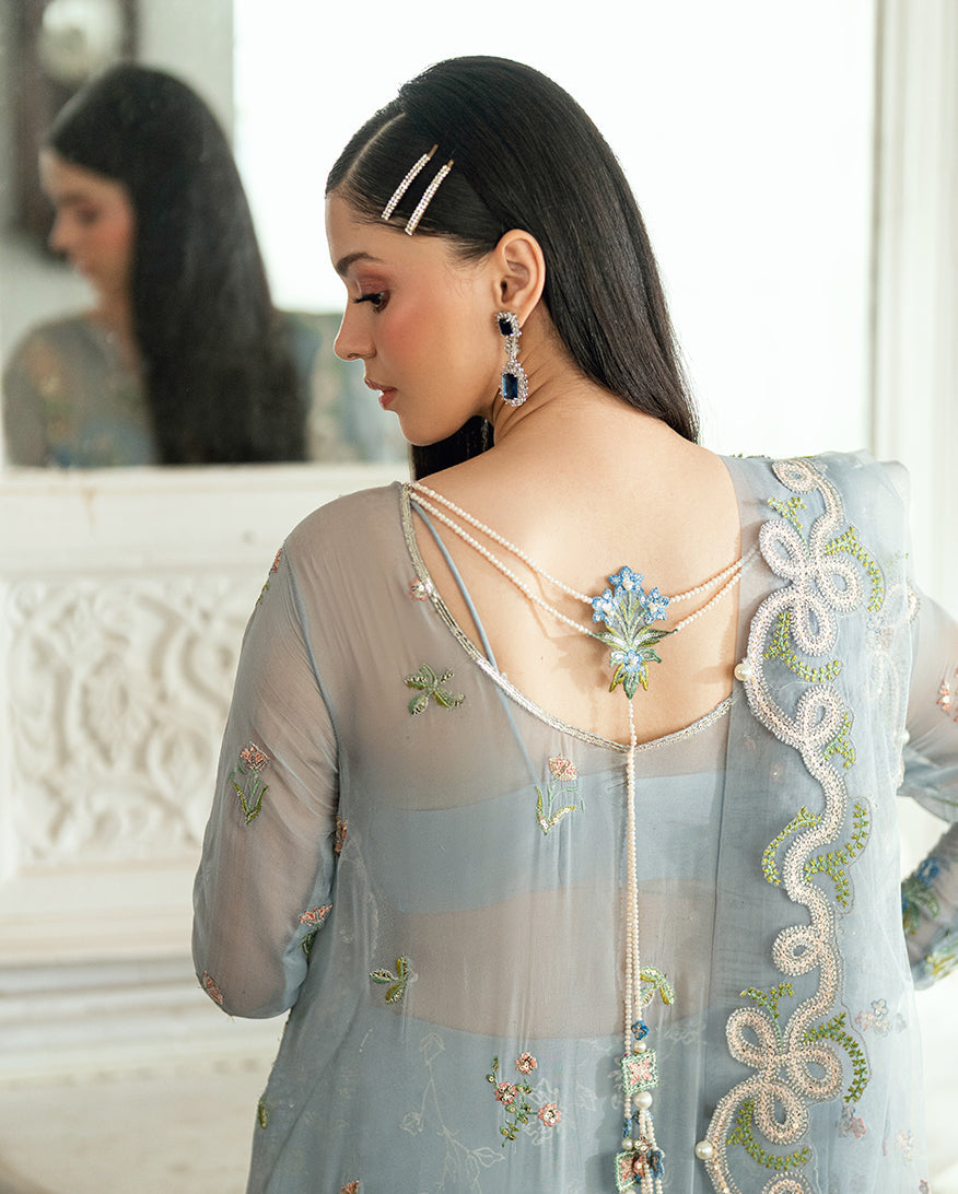 Back close-up showing pearl strings attached to embroidered floral motifs on sheer chiffon fabric