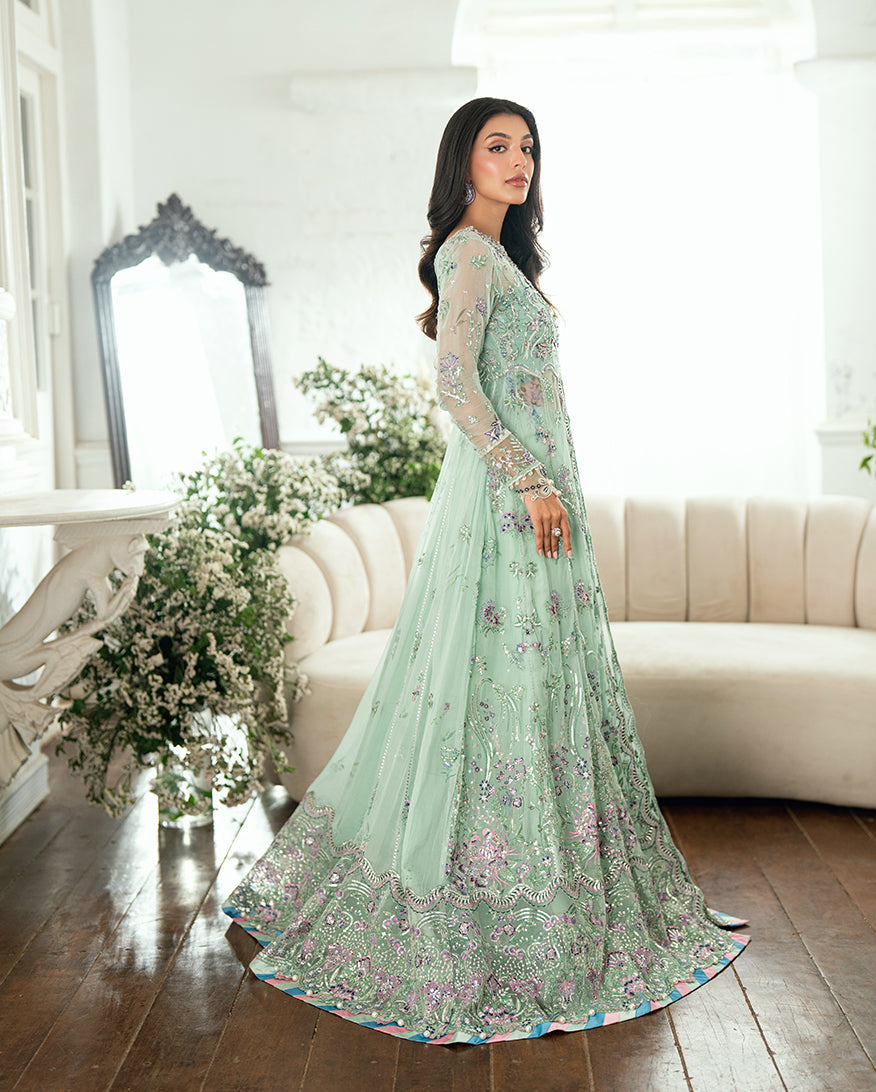 Side view of woman in embellished chiffon dress showing flowing skirt and embroidered long sleeves