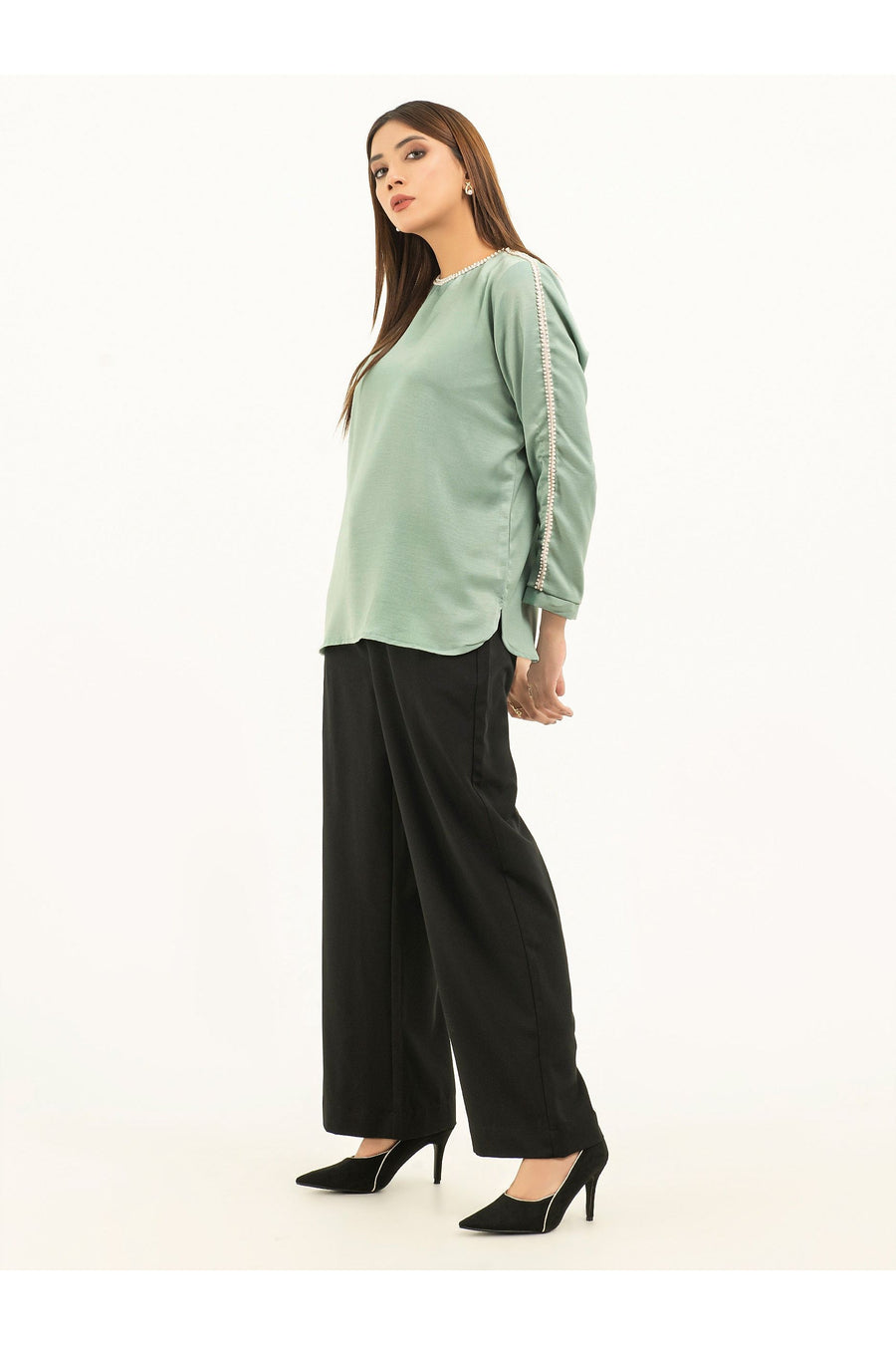 Side profile of model wearing green viscose top with pearl embellishments
