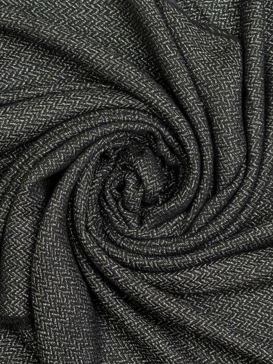Detailed view of charcoal wool shawl fabric twisted in a spiral to emphasize soft texture and pattern