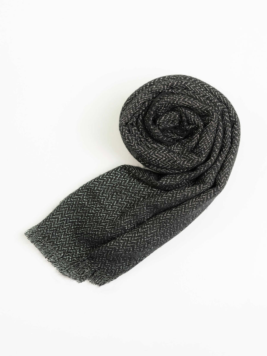 Charcoal wool shawl rolled neatly to highlight texture and lightweight fabric