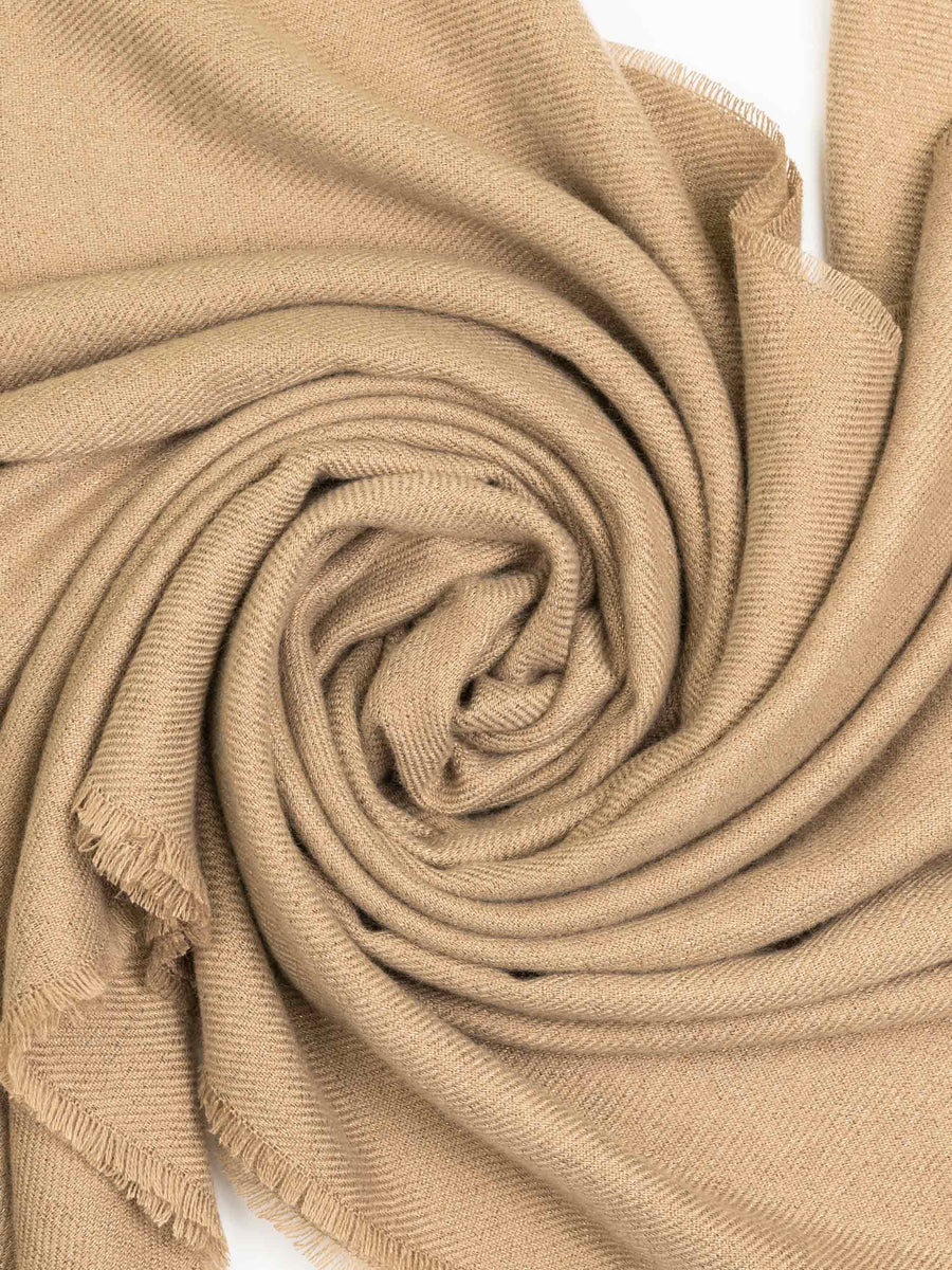 Swirled detail of camel wool shawl fabric showcasing softness and texture