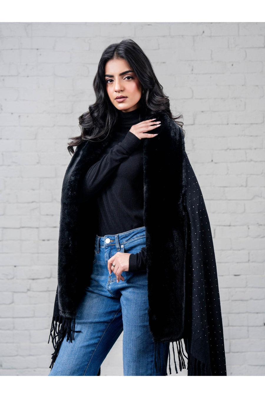 Close-up front view of woman elegantly posing in black wool cape shawl highlighting the soft texture and refined rhinestone details