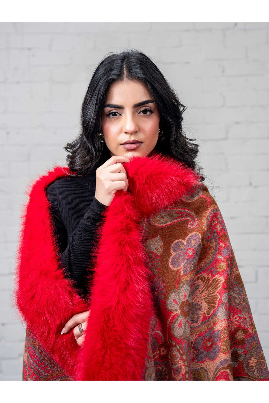 Close-up portrait of the woman wrapped in the cape, highlighting the softness of the faux fur trim and the intricate multi-colored floral design.