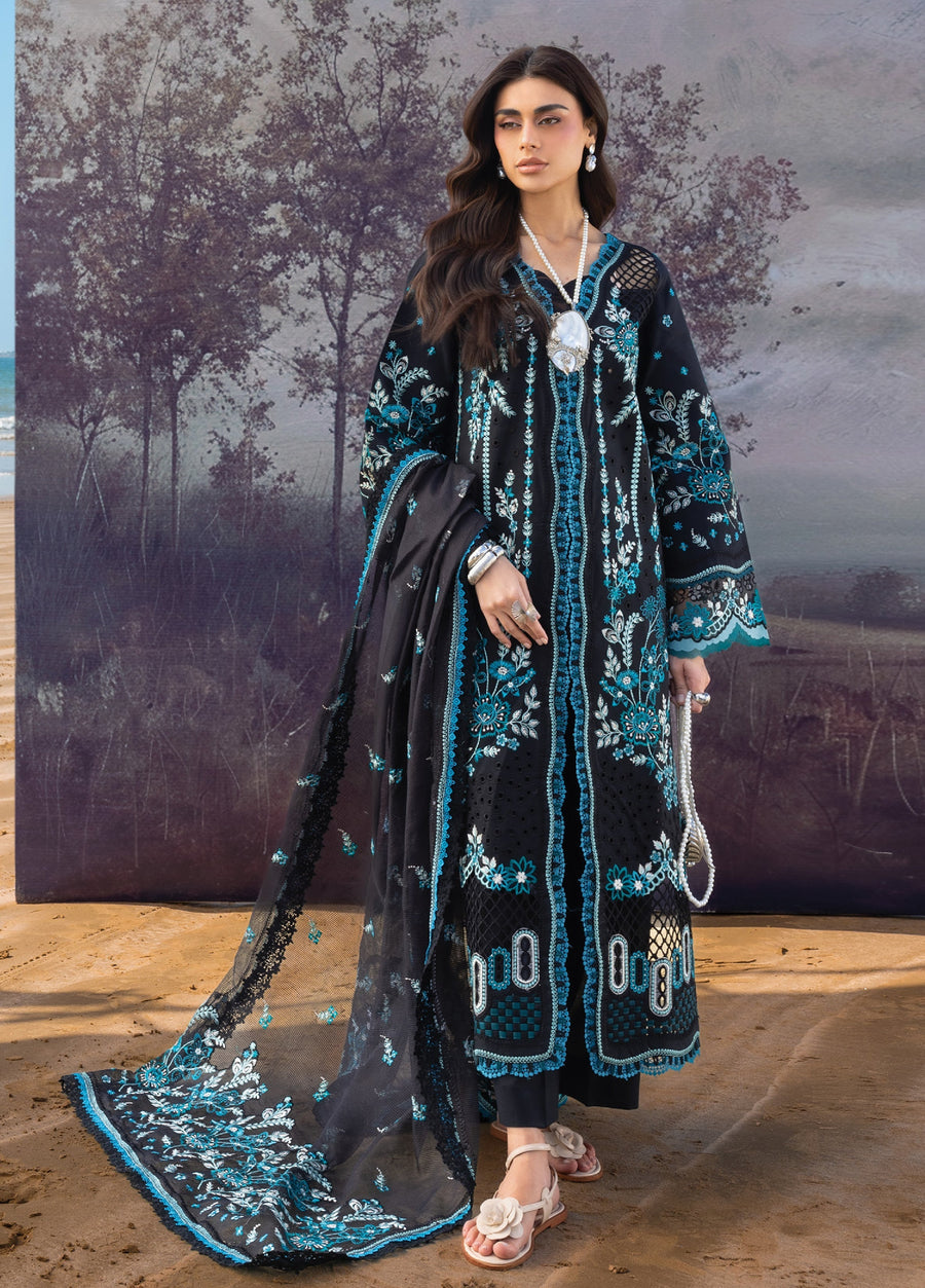 Woman wearing a black embroidered long shirt with aqua and white floral patterns, carrying a sheer embroidered dupatta on sandy beach background