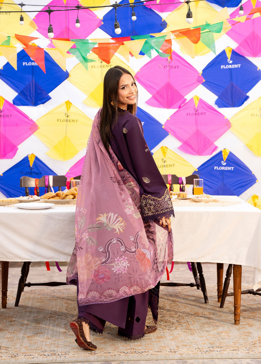 Back view of woman smiling, draped in pink floral printed chiffon dupatta with detailed embroidery on purple lawn suit and matching trousers.