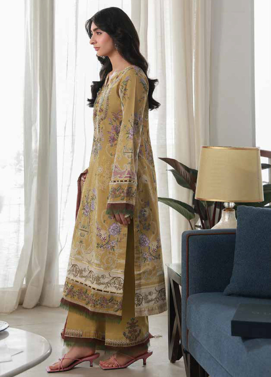 Side view of woman wearing mustard floral printed lawn shirt and dyed cotton trousers with printed borders, paired with pink strappy sandals.