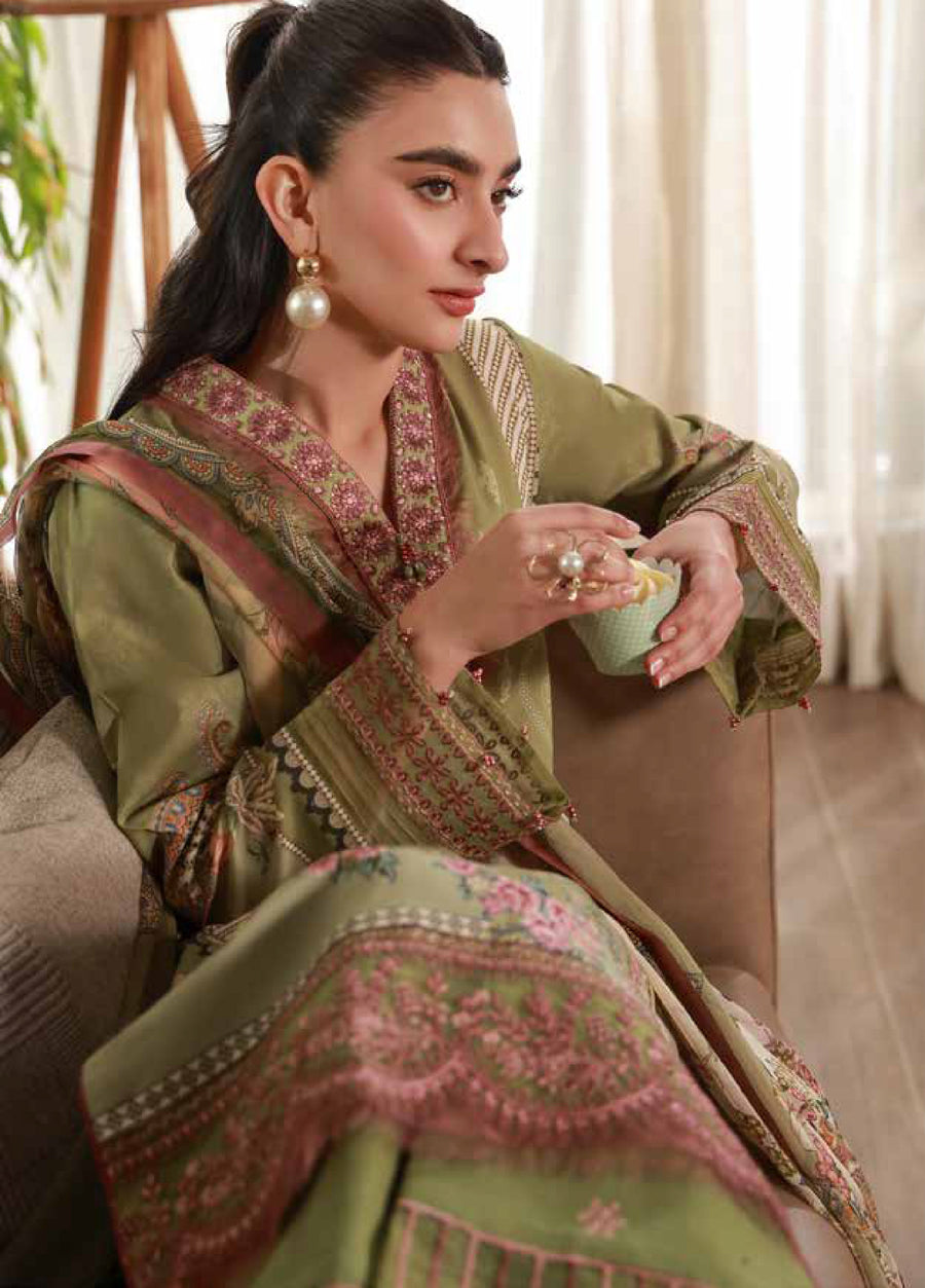 Close-up side view of a woman seated wearing the olive green embroidered lawn suit, highlighting the intricate embroidery on the neckline, sleeves, and flowing dupatta.